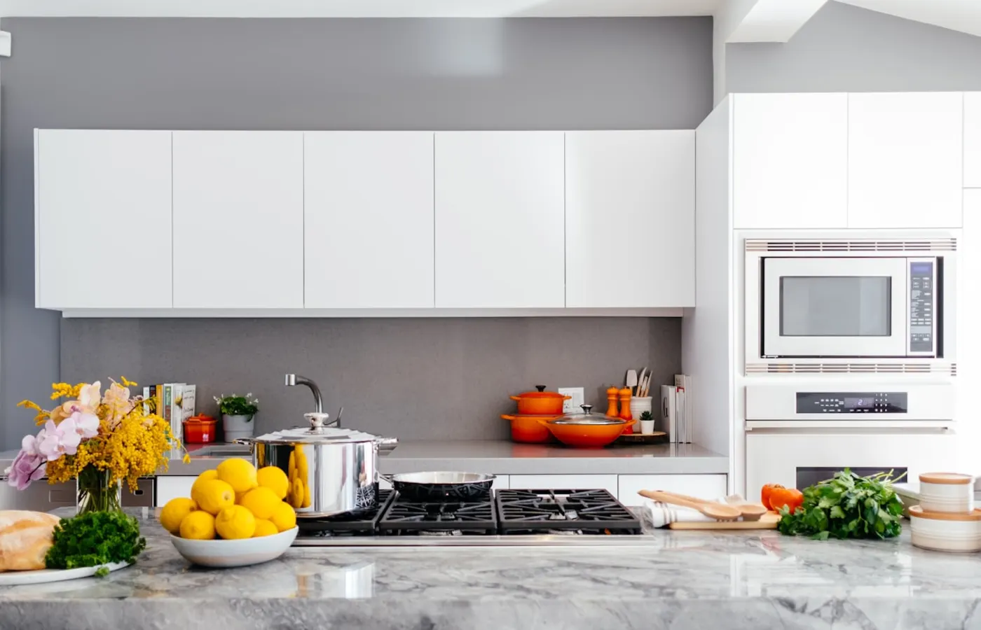A bright kitchen counter with cookware, food, and organized prep space.